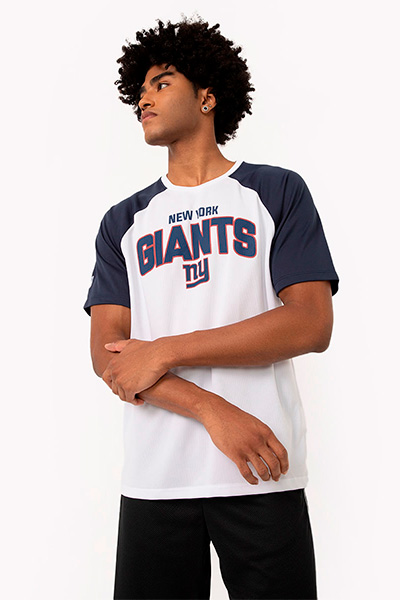 Modelo veste camiseta de time Giants, com o nome do time escrito no peito, em branco e com as mangas azul marinho