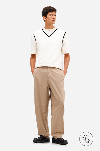 Modelo veste calça baggy masculina de sarja com cós de elástico bege - look com calça bege masculina - looks com calça bege masculina - o que combinar com calça bege masculina