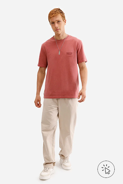 Modelo veste camiseta masculina de algodão vermelha e calça bege - look com calça bege masculina - looks com calça bege masculina - o que combinar com calça bege masculina