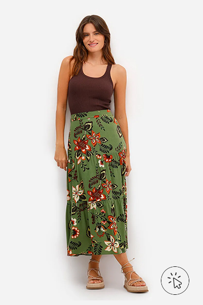 Modelo veste regata feminina de tricô canelada marrom e saia mídi estampada floral fundo verde - look marrom - roupa marrom combina com que cor