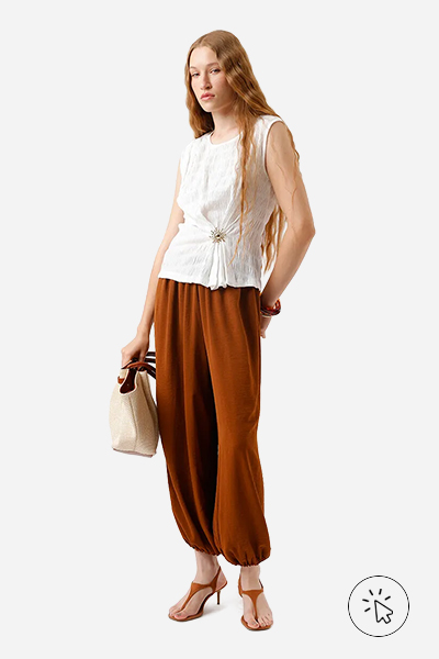 Modelo veste regata feminina texturizada com aviamento off-white e calça aladim marrom  - roupas para o ano novo - cores de roupa para o ano novo