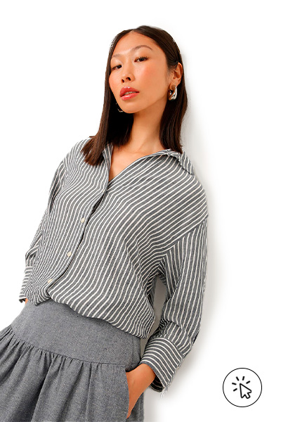 A modela está usando uma camisa listrada e uma saia cinza. - 7 estilos universais - quais são os 7 estilos universais - quem criou os 7 estilos universais - estilo tradicional - estilo clássico