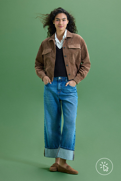 Modelo veste camisa branca feminina, suéter de tricô preto, jaqueta de suede marrom e calça jeans barra dobrada