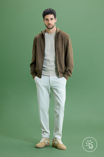 Modelo veste jaqueta masculina de suede marrom areia, camiseta cinza e calça off-white