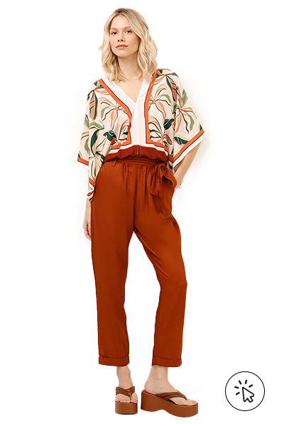 A modelo está usando uma bata florida e uma calça clochard laranja- o que comprar para o dia das mães