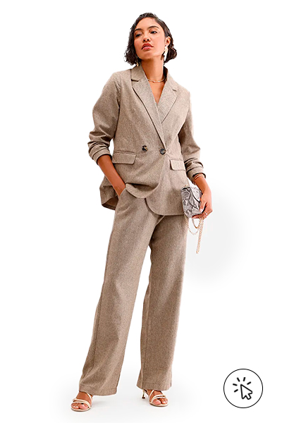 A modelo está usando um blazer e uma calça de alfaiataria, salto nos pés e está segurando uma bolsa - o que dar de presente de dia das mães - o que comprar para o dia das mães - roupa para o dia das mães