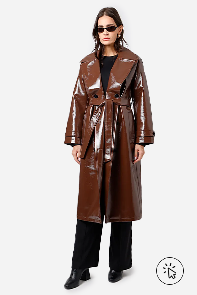 Modelo veste trench coat de PU marrom com acabamento brilhante, calça wide leg preta e botas