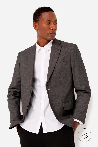 Modelo veste blazer texturizado com bolsos e ombreiros na cor chumbo, camisa social branca e calça de alfaiataria preta - o que é um traje esporte fino - traje esporte fino - look esporte fino masculino - look esporte fino - estilo esporte fino
