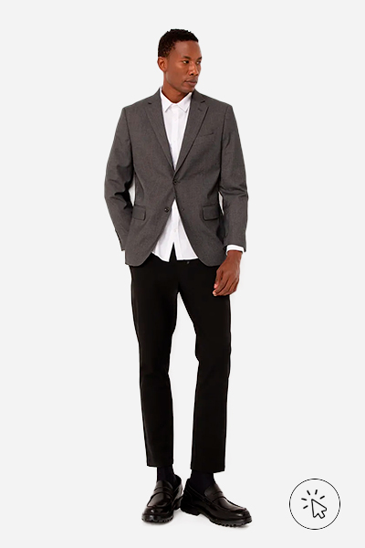 Modelo veste blazer texturizado com bolsos e ombreiros na cor chumbo, camisa social branca e calça de alfaiataria preta - o que é um traje esporte fino - traje esporte fino - look esporte fino masculino - look esporte fino - estilo esporte fino
