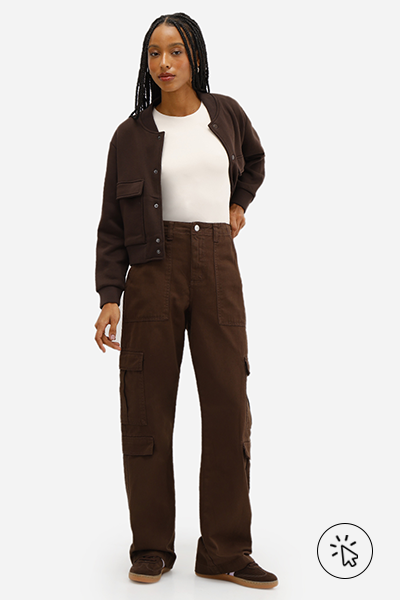 Modelo veste jaqueta marrom e calça cargo feminina de sarja cintura média marrom