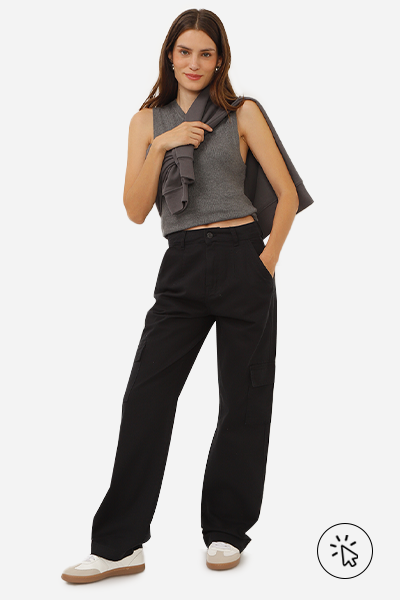 Modelo veste regata cropped cinza com suéter cinza amarrado nos ombros e calça wide leg cargo de sarja cintura alta preta