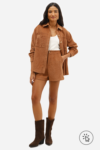 Modelo veste jaqueta oversized de veludo cotelê caramelo e short feminino no mesmo material e cor