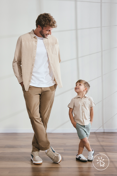 Modelo veste camiseta masculina branca, camisa de linho bege por cima e calça káki. Ao lado, modelo infantil veste camisa manga curta de linho bege e bermuda azul clara