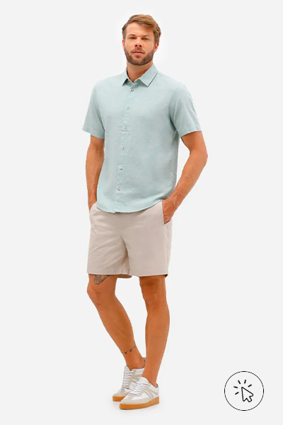 Modelo veste polo verde menta e bermuda bege
