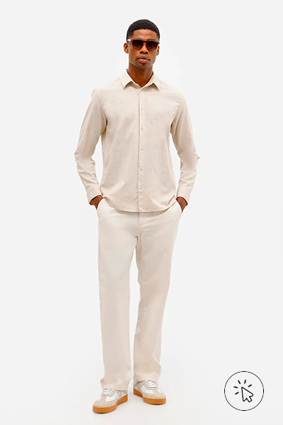 Modelo veste camisa masculina de linha e algodão manga longa bege e calça bege