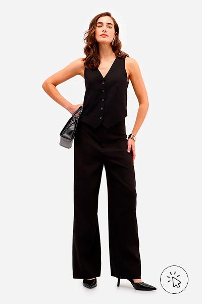 Modelo veste colete feminino de alfaiataria em viscose preto e calça de alfaiataria pantalona na mesma cor