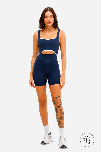 Modelo veste macaquinho feminino esportivo ACE de poliamida com recorte azul marinho com detalhes em branco