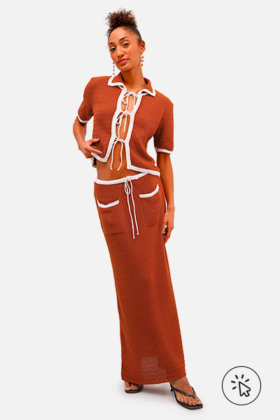 Modelo veste conjunto de blusa de amarração frontal com laços e saia mídi feminina de tricô com bolsos caramelo