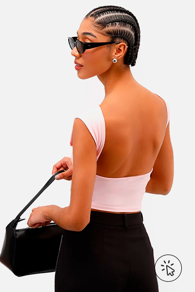 Modelo veste top feminino de poliamida com decote nas costas rosa bebê e calça preta