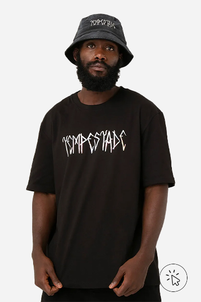 Modelo veste camiseta oversized preta Marvel, bucket hat Marvel e bermuda preta - look comfy para show de trap - o que é comfy