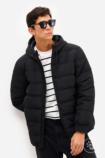 Modelo veste jaqueta puffer preta, calça jeans preta, blusa listrada bicolor e óculos escuros - look comfy para show de trap - o que é comfy