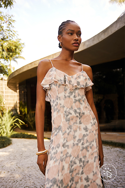 Modelo veste vestido mídi alças finas com babados no decote e estampa floral rosa pastel