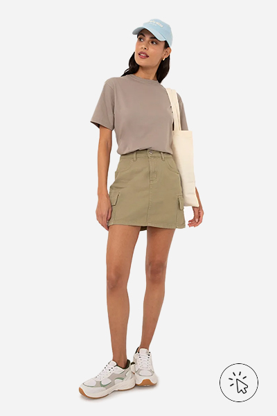 Modelo veste saia cargo cintura média com bolso verde claro e camiseta cropped cinza - cores que combinam com cinza - looks com cinza