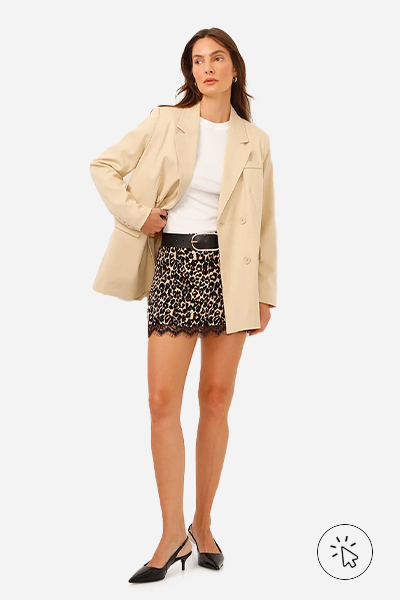 Modelo veste blazer de alfaiataria oversized bege e minissaia animal print com renda na barra