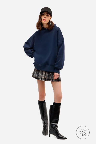 Modelo veste blusão unissex de moletom com capuz azul marinho da coleção C&A & Stylists assinado por Yan Acioli