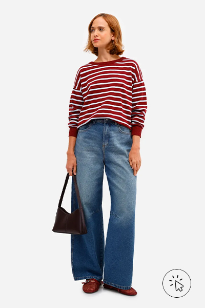 Modelo veste suéter feminino de tricô listrado vinho e calça wide leg jeans