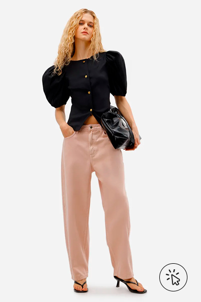 Modelo veste blusa feminina de tafetá manga bufante preta e calça rosa pastel
