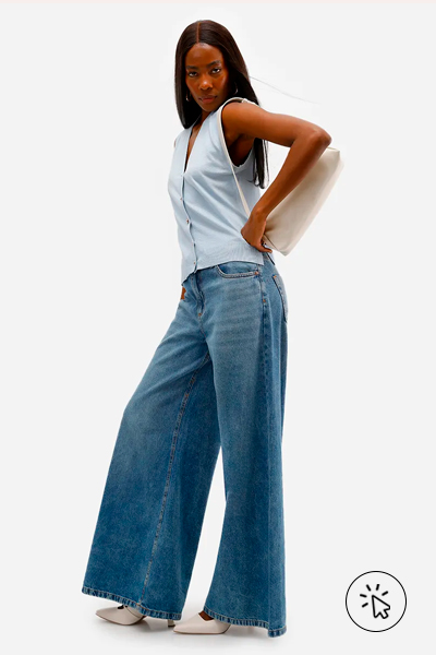 Modelo veste colete feminino de tricô com fendas azul e calça jeans super wide leg
