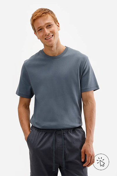 Modelo com camiseta cinza e calça escura. - o que combina com calça jeans clara masculina - como usar calça jeans clara masculina