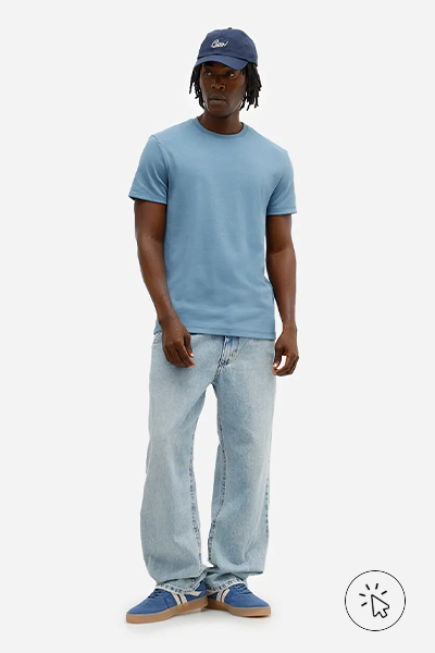 O modelo está usando uma camiseta azul, calça jeans clara, tênis casual e boné. - o que combina com calça jeans clara masculina - como usar calça jeans clara masculina