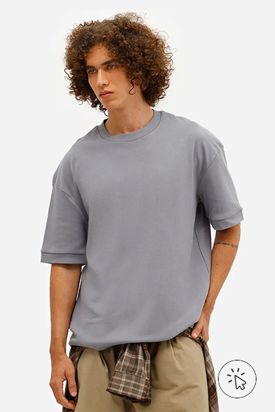 O modelo está usando uma camiseta oversized cinza e uma calça clara. - o que combina com calça jeans clara masculina - como usar calça jeans clara masculina