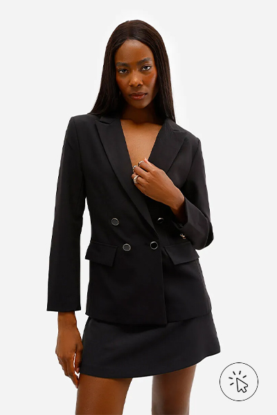 Modelo veste blazer preto e short-saia preto de alfaiataria - tecidos que não desbotam