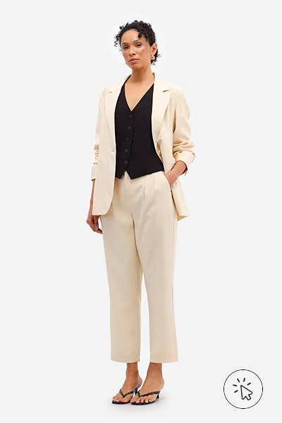 Modelo veste blazer feminino de alfaiataria com viscose amarelo claro e calça de alfaiataria com pregas no mesmo tom - cores que combinam com amarelo - que cores combinam com amarelo