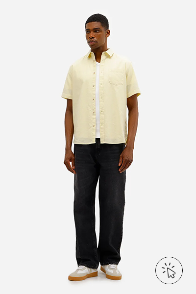 Modelo veste camisa comfort masculina com linho mangas curtas amarelo claro e calça preta - cores que combinam com amarelo - que cores combinam com amarelo
