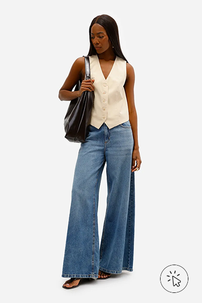 Modelo veste colete feminino de alfaiataria em viscose amarelo e calça jeans super wide leg - cores que combinam com amarelo - que cores combinam com amarelo