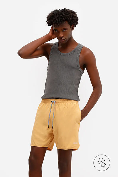Modelo veste regata cinza e short masculino com cós de elástico amarelo - cores que combinam com amarelo - que cores combinam com amarelo