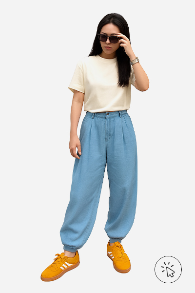 Modelo com calça jeans aladim, camiseta de algodão peruano e tênis amarelo.