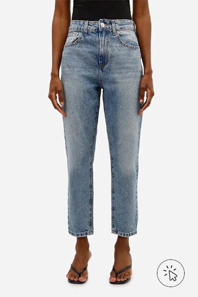 Modelo veste blusa preta, calça mom jeans azul de corte reto com aplicações de brilhos e sandálias de tiras finas preta - roupas anos 80 - look anos 80 - moda anos 80 - como era a moda nos anos 80