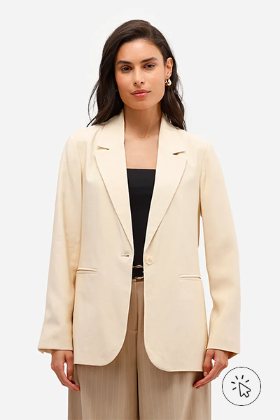 Modelo veste blazer bege, blusa preta e calça de alfaiataria bege com listras finas - roupas anos 80 - look anos 80 - moda anos 80 - como era a moda nos anos 80
