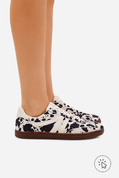 Foto destacando os pés da modelo usando o tênis Bossa off-white com estampa cow print ACE - roupas anos 80 - look anos 80 - moda anos 80 - como era a moda nos anos 80