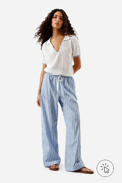 Modelo veste calça pijama feminina com algodão listrada azul