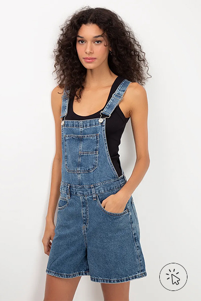 Modelo veste jardineira jeans com bolsos azul - roupas anos 90 - look anos 90 - moda anos 90 - como era a moda nos anos 90