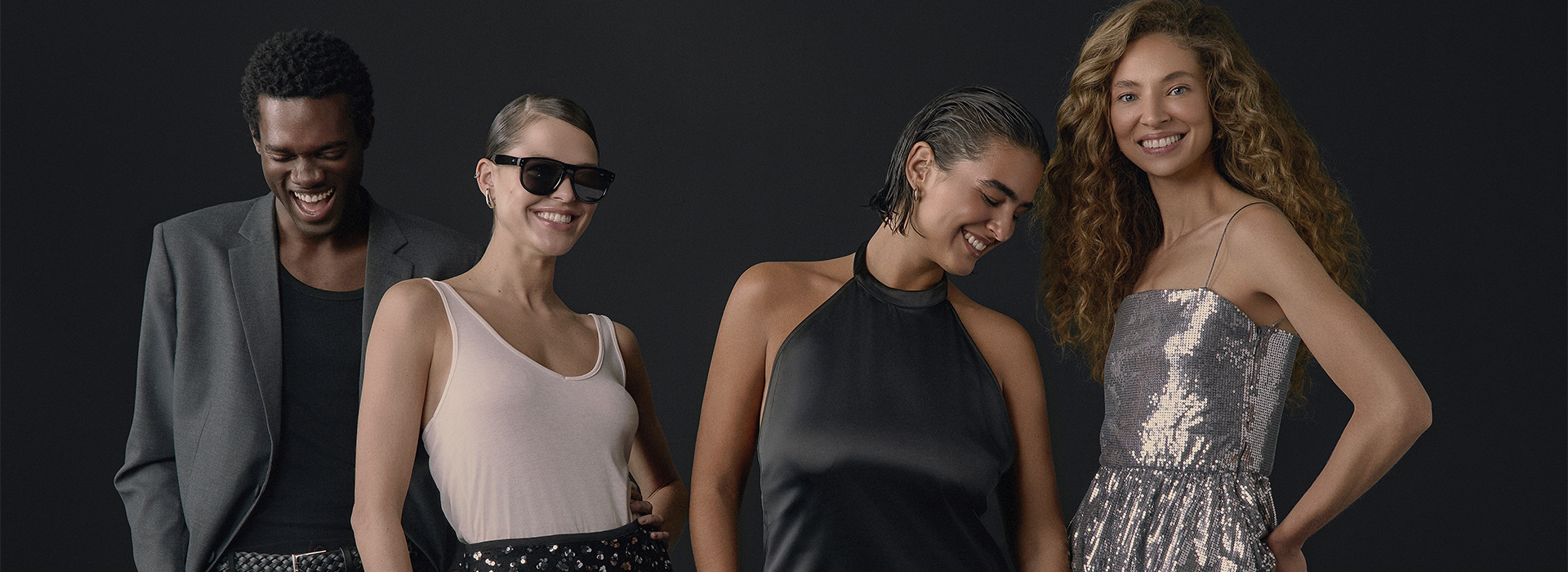 Vários modelos com looks da Black Friday da C&A. O fundo da imagem é preto.
