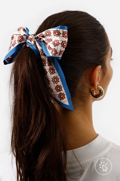 Modelo usa lenço faixa feminino acetinado colorido azul e vermelho como laço no cabelo