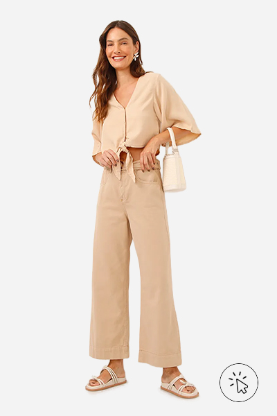 Modelo veste camisa cropped de liocel decote V com amarração bege káki