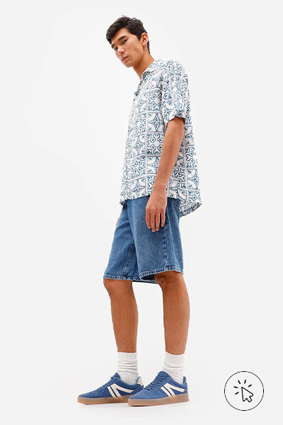 Modelo veste bermdua baggy masculina jeans azul médio